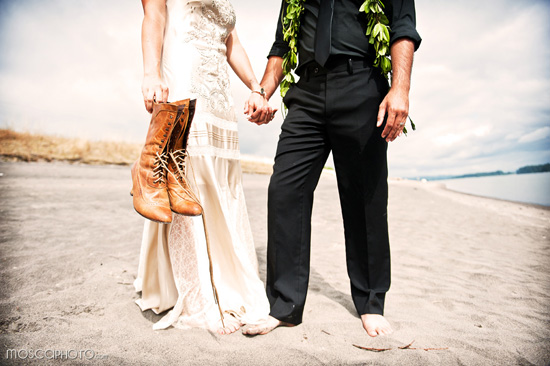 Barefoot bride with cowboy boots on beach wedding day