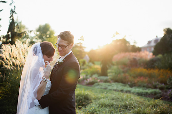 Bride and groom embrace at outdoor garden wedding