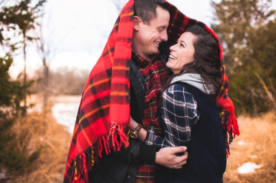 Happy couple sharing a cozy blanket outdoors