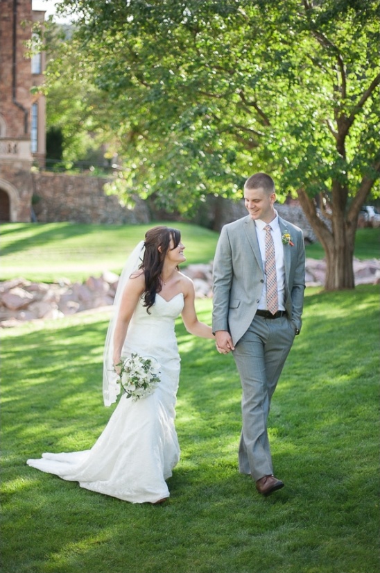 Happy couple walking hand in hand on a grassy lawn
