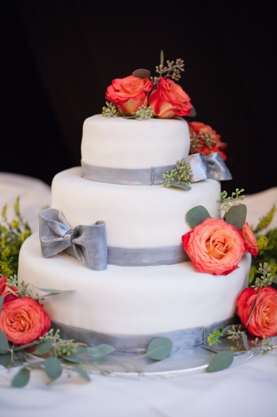 Elegant three-tiered wedding cake with coral roses