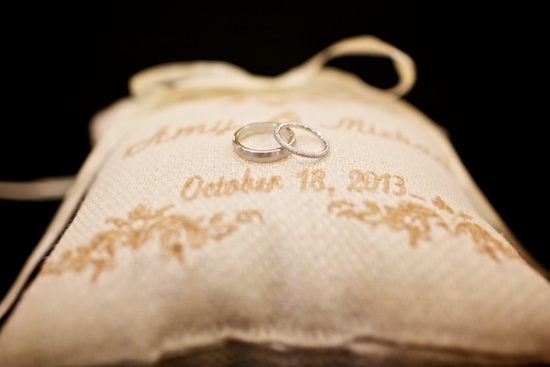 Wedding rings on a pillow with wedding date details