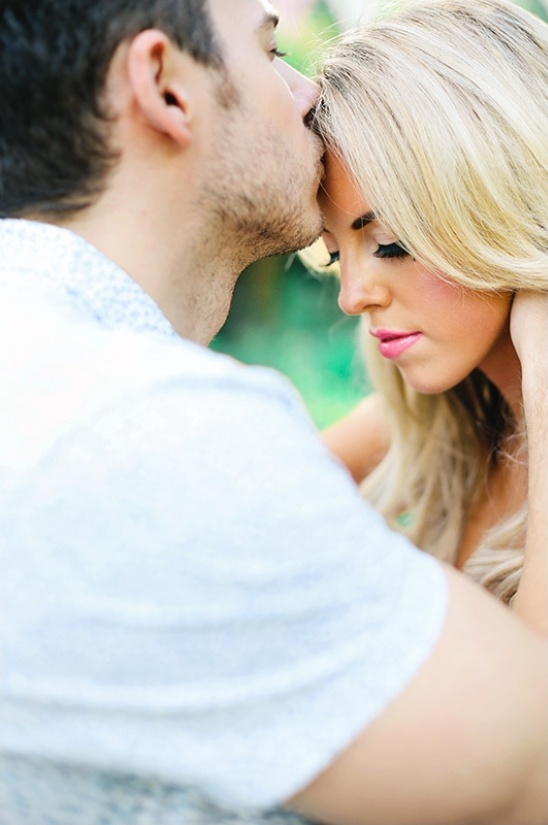 Man kissing woman on forehead in gentle embrace