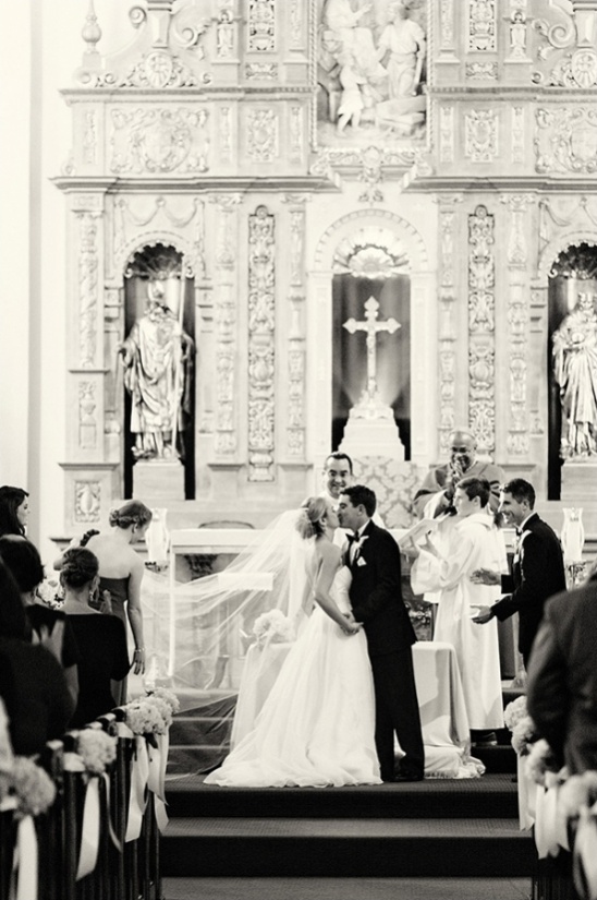 Bride and groom kiss in a beautiful church during the wedding ceremony