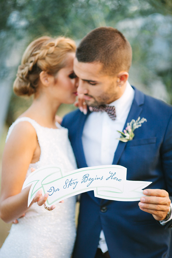 Here are a few options for the alt tag:

Option 1: **Bride whispers groom our story begins banner** (46 characters)
Option 2: **Wedding couple their story begins here banner** (44 characters)
Option 3: **Romantic wedding couple story begins here** (45 characters)

Option 1 is more descriptive of the action in the image  Option 2 and 3 are more generic but still relevant 

**Option 1 is chosen as the best as it is more expressive and descriptive **

**Alt tag:** `Bride whispers groom our story begins banner`