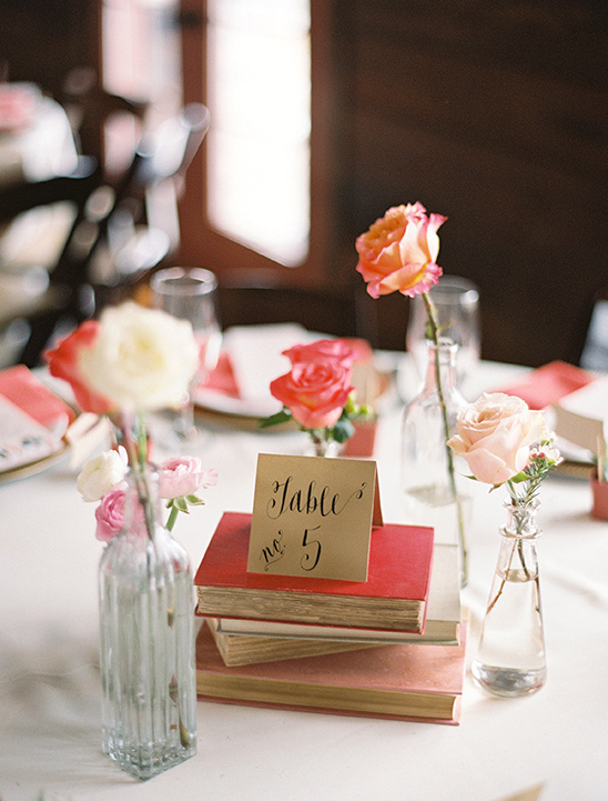 Wedding table decor with books roses and table number