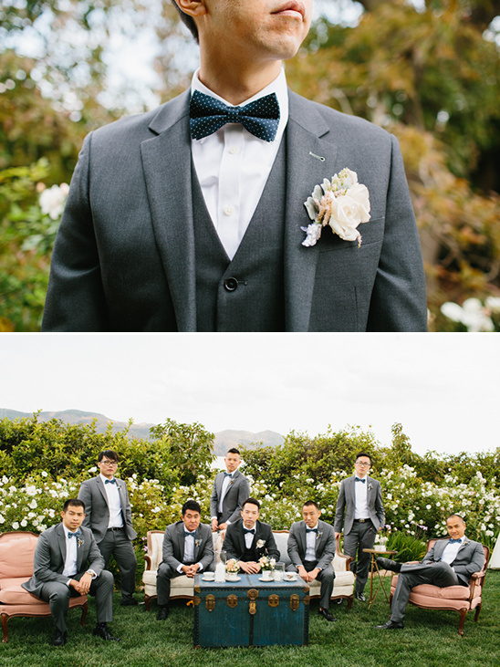 Groomsmen in gray suits and bowties at outdoor wedding