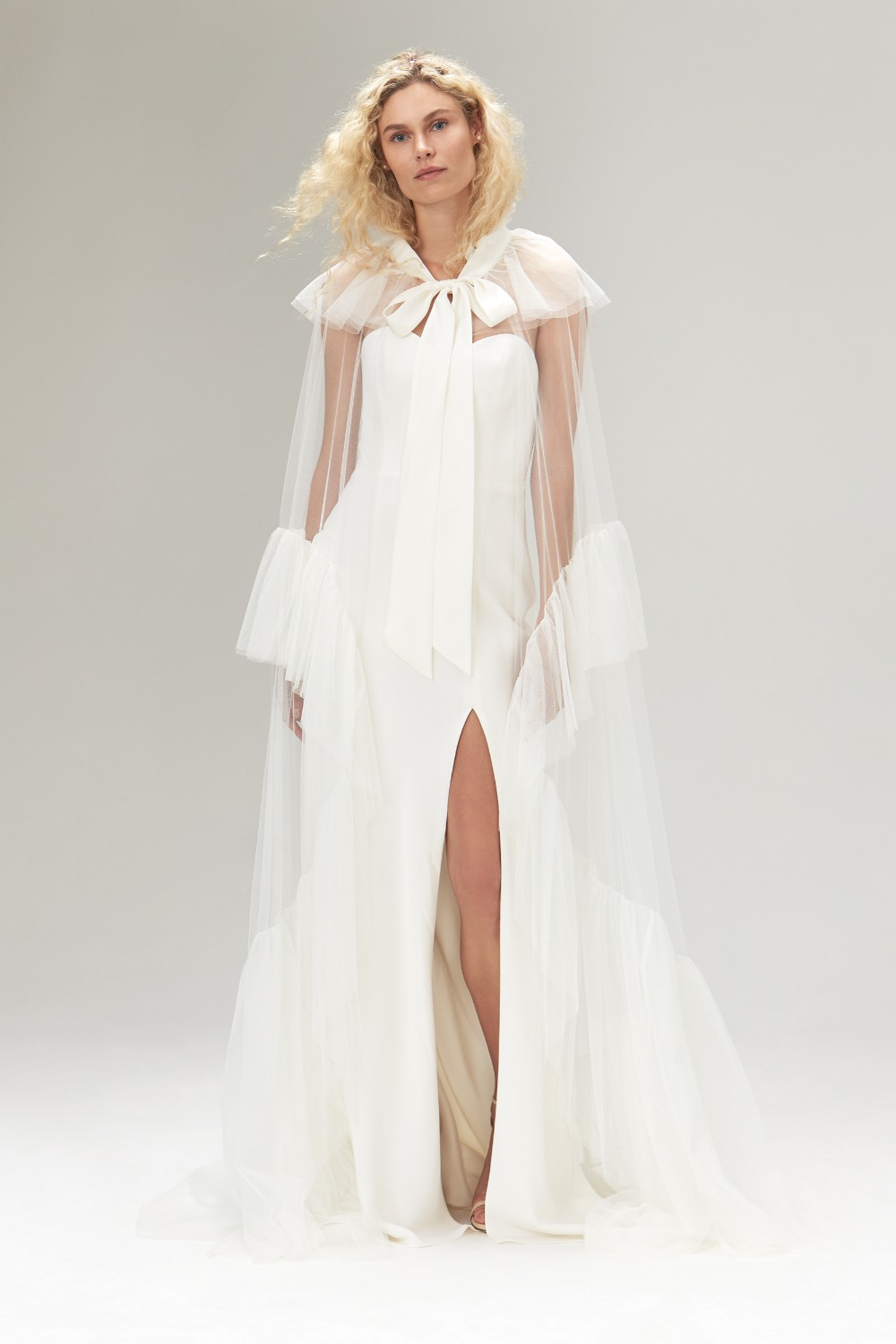 Elegant bride in white gown and sheer cape