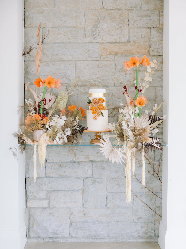 Elegant tiered wedding cake with orange floral accents