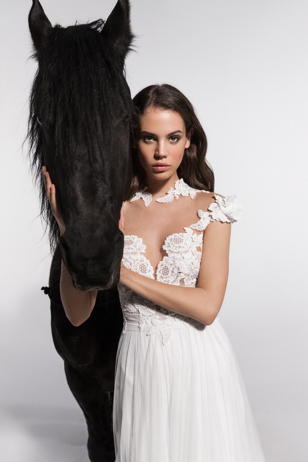 Bride in lace gown with a beautiful black Friesian horse