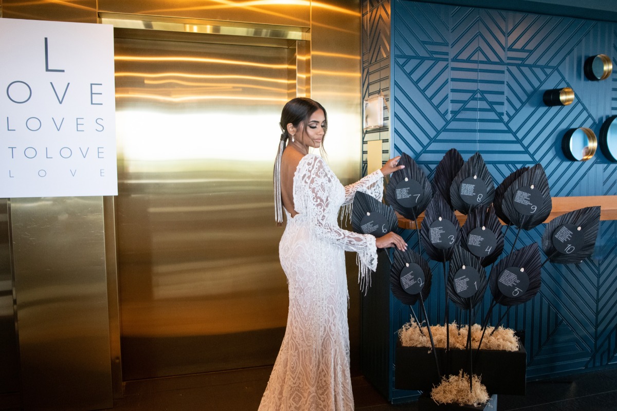 Elegant bride in a white gown arranging wedding seating cards