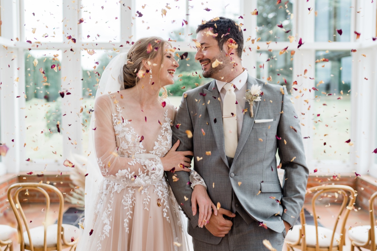 Newlyweds share a joyful moment in wedding confetti