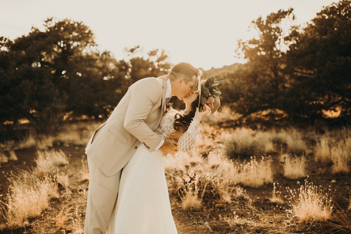Romantic wedding couple kissing outdoors at sunset