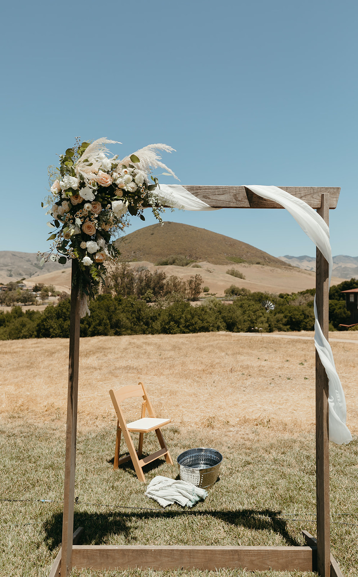 Beautiful outdoor wedding arch with flowers and fabric